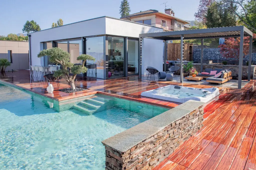 Aménagement extérieur d'une villa avec piscine en béton brut et paroi de verre à Évian-Les-Bains en Haute-Savoie (74)