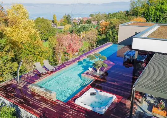 Conception et réalisation des aménagements extérieurs d’une villa et d’une piscine en béton brut avec paroi de verre
