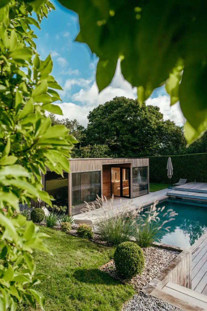 Pool house en bois moderne avec piscine et jardin paysager luxuriant à Neuvecelle en Haute-Savoie (74)