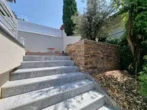 Escalier en pierre naturelle et mur de soutènement en pierre sèche dans un jardin paysager à Évian-Les-Bains