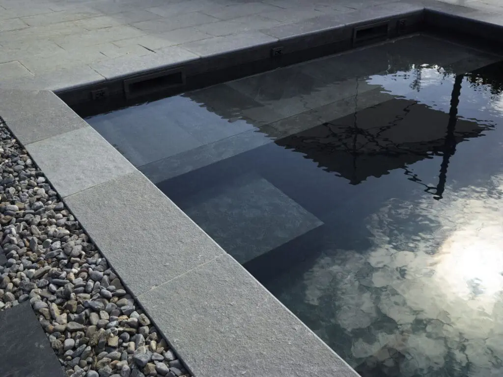 Margelles en pierre naturelle autour d'une piscine avec volet roulant immergé à Thonon-Les-Bains