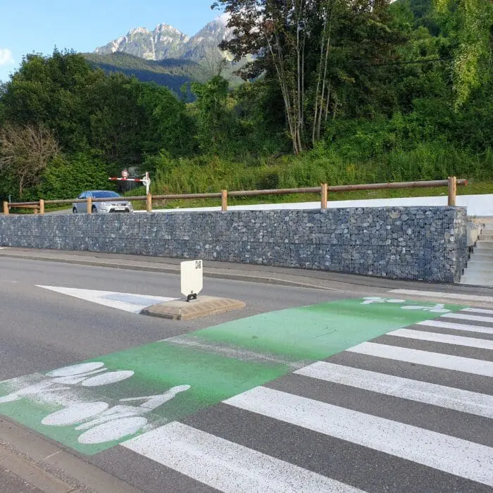 Aménagement urbain à Saint-Gingolph avec mur de soutènement en gabions, parking, piste cyclable et passage piéton