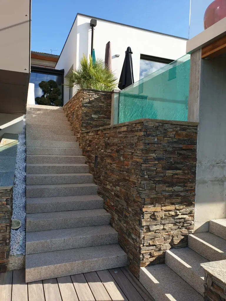 Escalier en pierre menant à une piscine avec paroi en verre à Évian-Les-Bains en Haute-Savoie (74)
