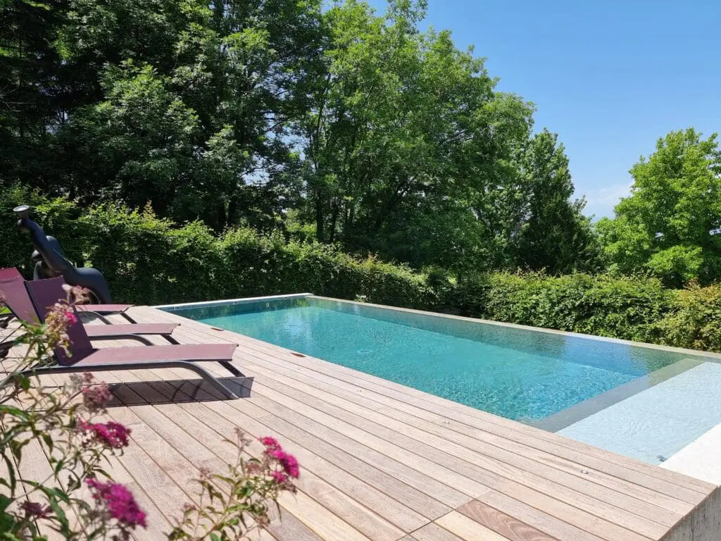 Piscine à débordement avec plage en bois exotique et vue panoramique à Thonon-les-Bains, réalisée par Pernollet Paysage