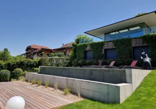 Conception et réalisation d’une piscine à débordement en béton brut et aménagement paysager à Publier (Haute-Savoie – 74)