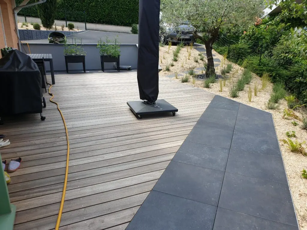 Terrasse en bois exotique et grès cérame avec vue sur un aménagement paysager, réalisée par Pernollet Paysage à Publier.