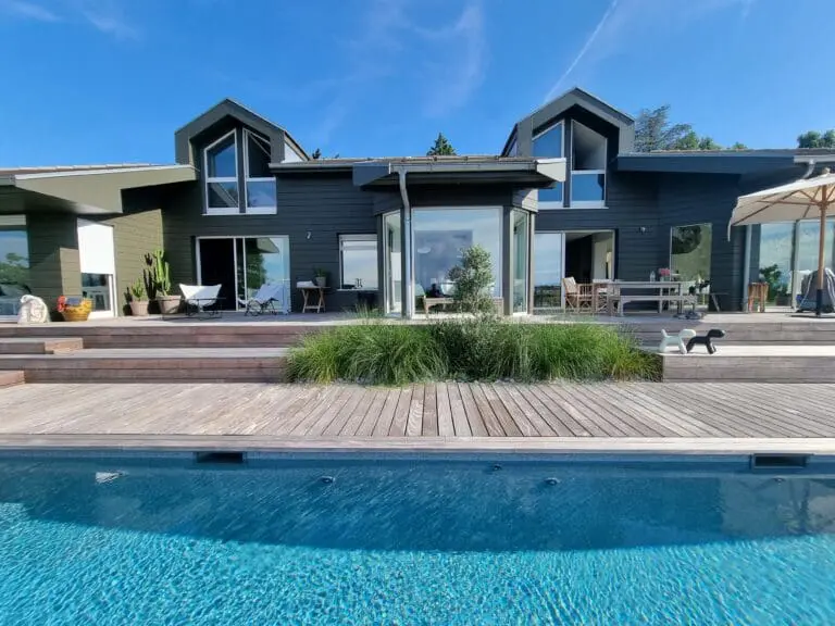 Massif paysager sur terrasse avec olivier et graminées à Neuvecelle, conçu par Pernollet Paysage.