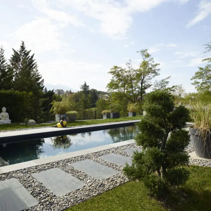 Piscine sur mesure avec terrasse en pierre calcaire et aménagement paysager à Thonon-les-Bains