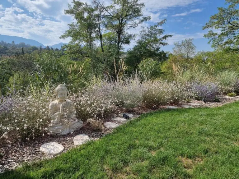 Massif méditerranéen fleuri avec statue de Bouddha pour une ambiance zen