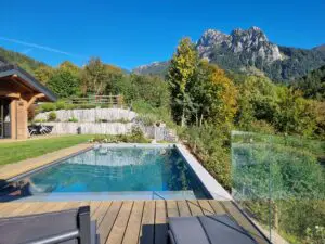 Terrasse de piscine sur mesure à Bernex avec bains de soleil et vue panoramique sur les montagnes