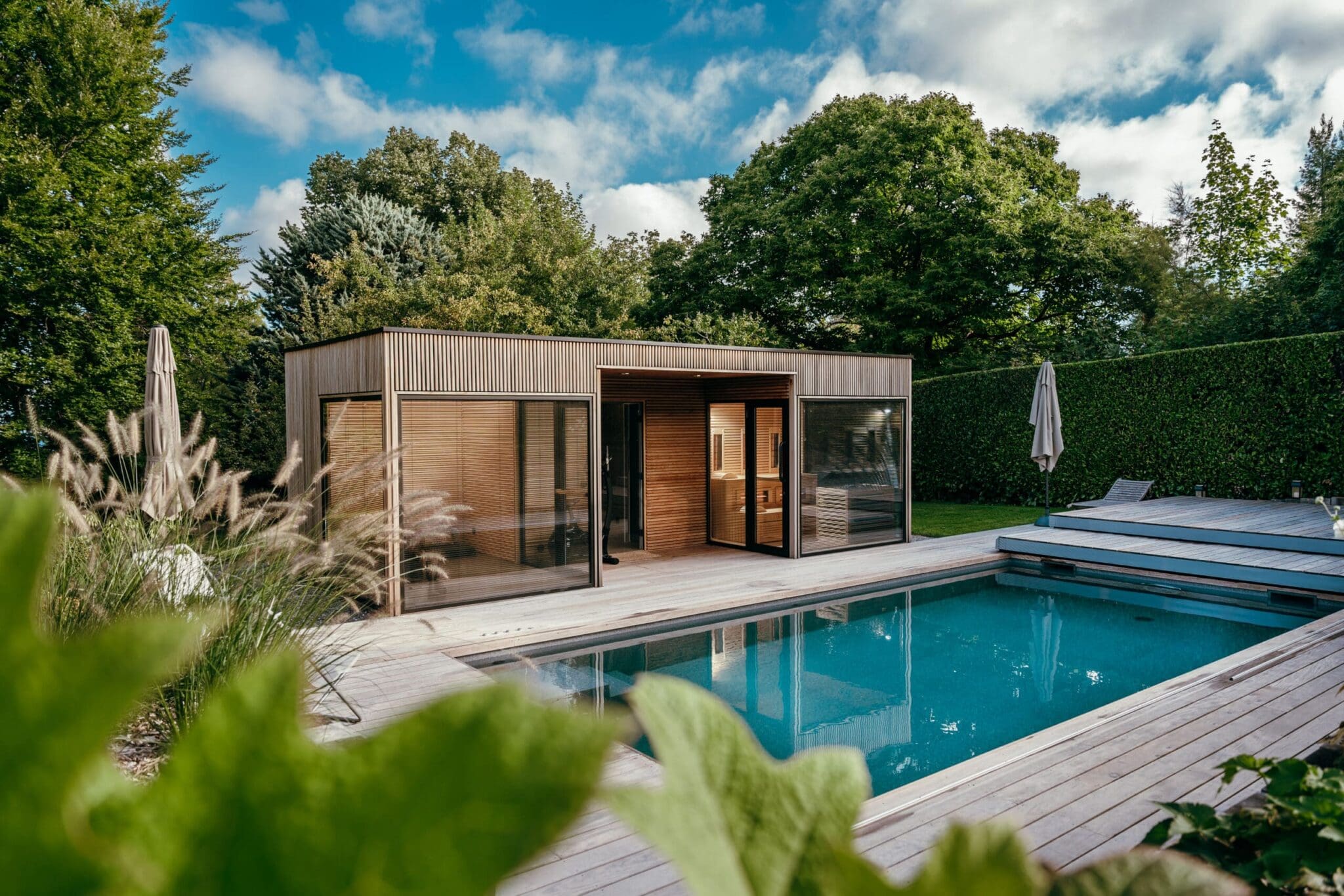 Pool house en bois avec grande piscine et jardin paysager luxuriant à Neuvecelle en Haute-Savoie (74)