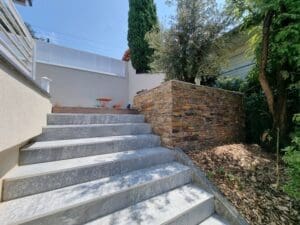 Escalier en pierre naturelle et mur de soutènement en pierre sèche dans un jardin paysager à Évian-Les-Bains