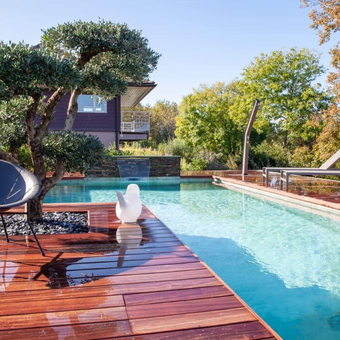 Piscine rectangulaire avec terrasse en bois, jardin paysager et vue sur le lac à Évian-Les-Bains en Haute-Savoie (74)